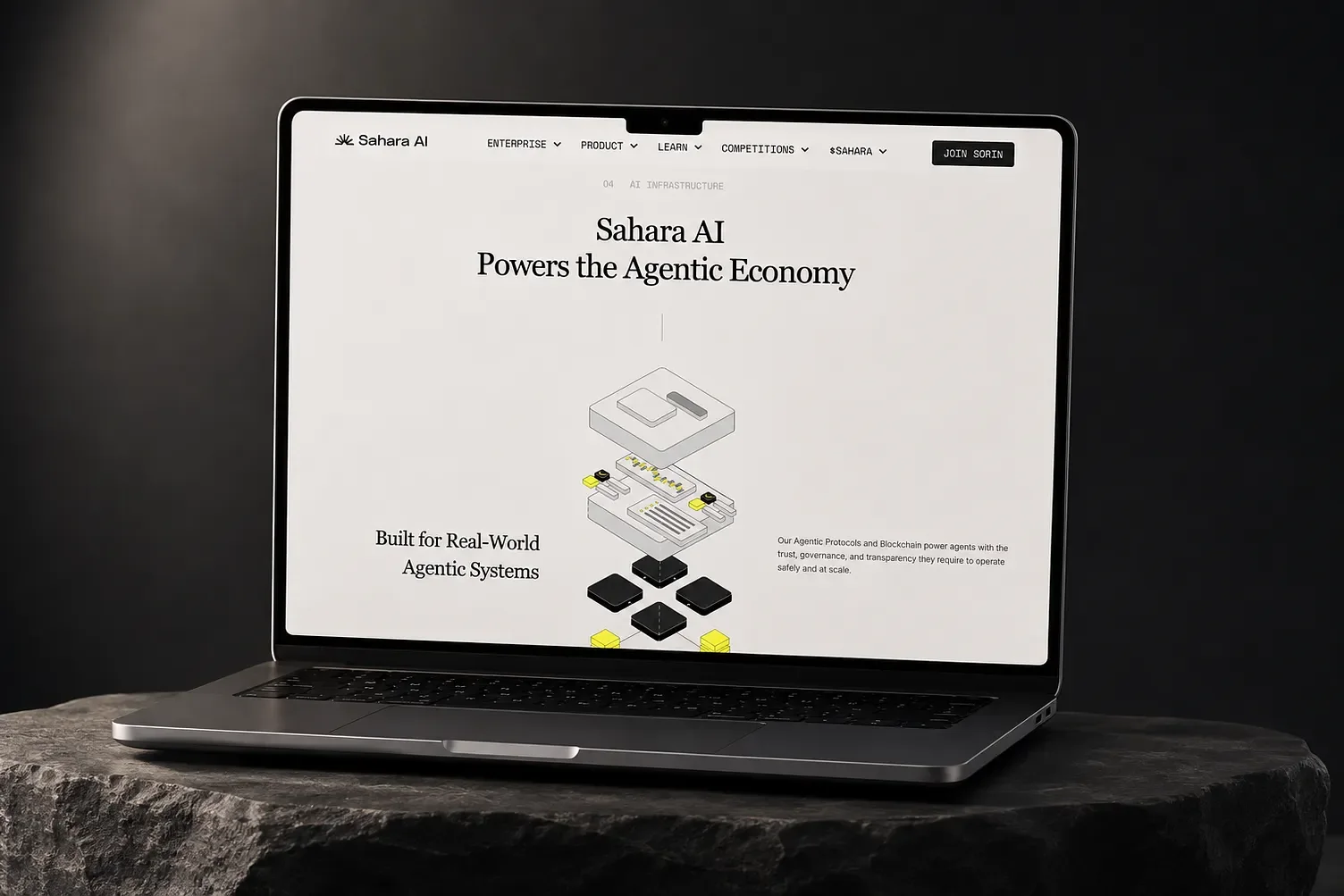 ノートPCに表示したSahara AIのWebサイト。セリフ体の見出し「Sahara AI Powers the Agentic Economy」と、黒と黄色のブロックが積み重なるアイソメトリック図